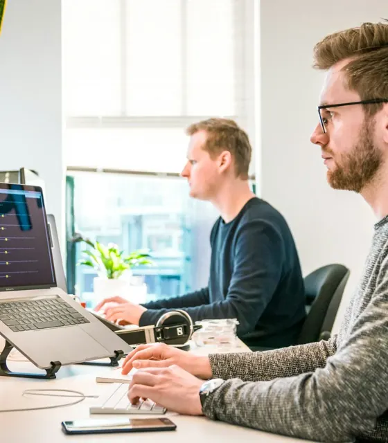 Dos personas analizando datos de posicionamiento SEO en Google en sus ordenadores